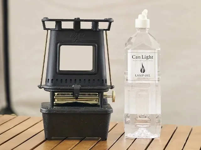 WAQのアイロンストーブとパラフィンオイルの容器がテーブルの上に置かれているシーン。