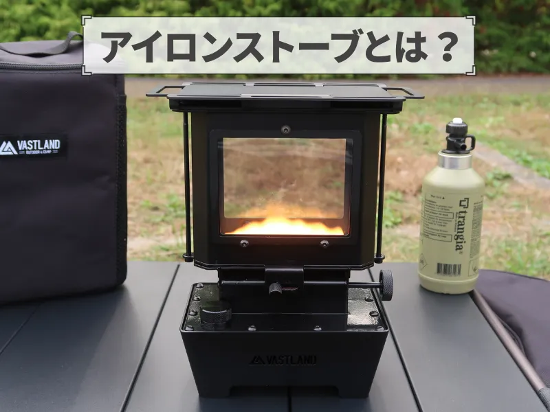 キャンプ場でVASTLANDのアイロンストーブを使用しているシーン、炎が灯り「アイロンストーブとは?」の文字が表示されている。