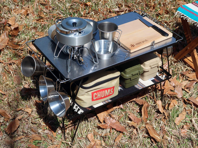 キャンプ用ラックを2段に重ねて、食器や調理器具を置いている