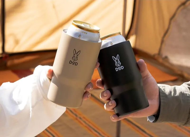DOD「モッテコ・ウサーモ」のブラックとタンの2色に缶飲料を入れ、テント内で乾杯しているアウトドアシーン。