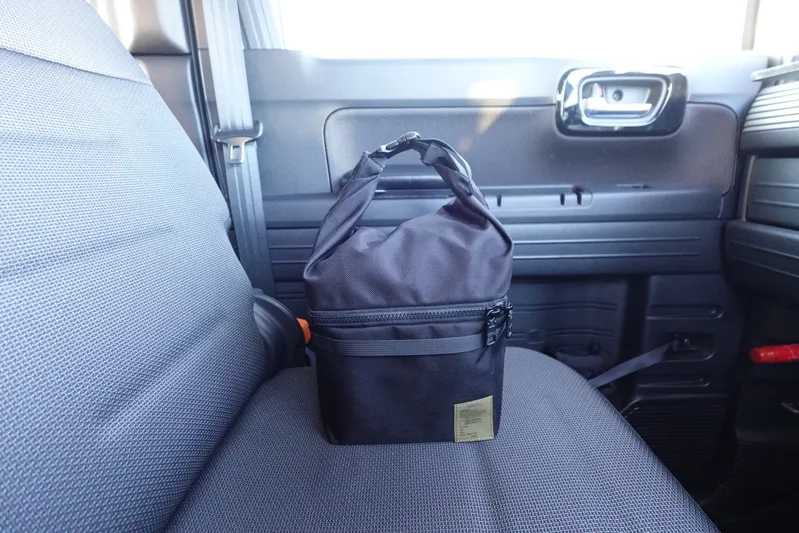 シャンクヒーター（AS2OV別注）をケースに収納し、車の助手席シートに置いた様子。コンパクトで持ち運びやすいサイズ感が分かる。