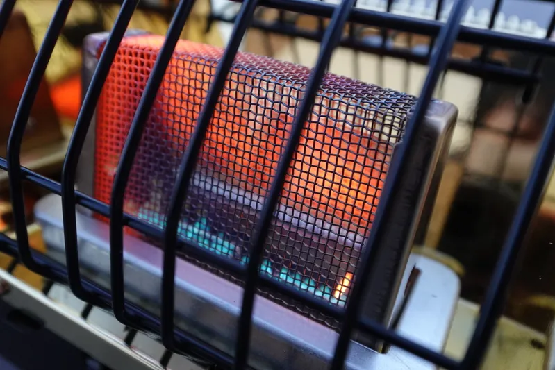 シャンクヒーターの燃焼部アップ。赤熱した熱源と青い炎が見えるガス燃焼式の屋外用ヒーター。