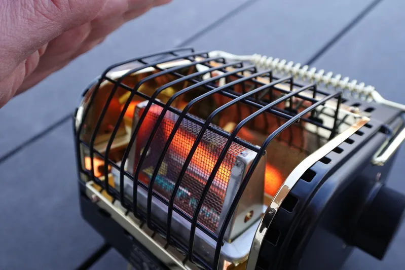 シャンクヒーターAS2OV別注で手元をスポット暖房する様子。大きな暖房が不要な人に適した超小型ガスストーブ。