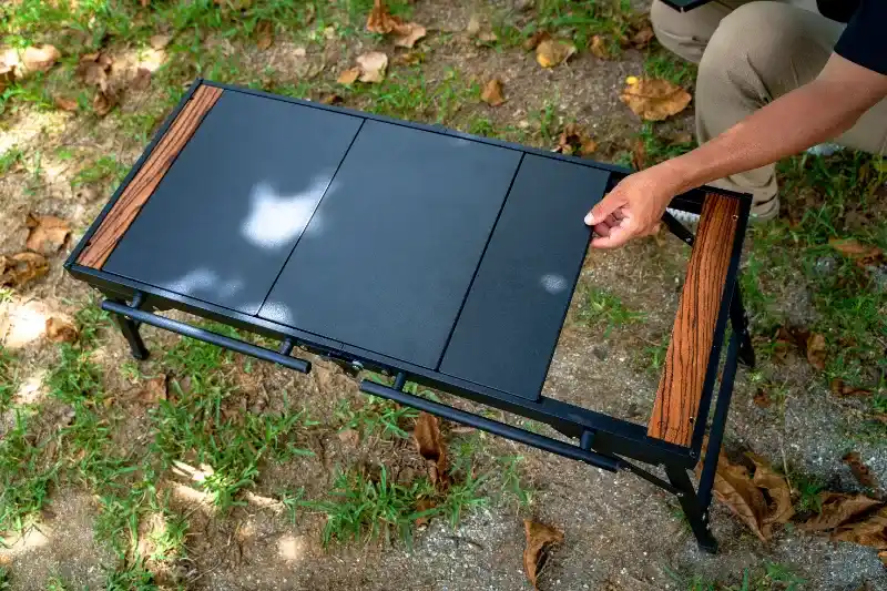 ZENキャンプ(ZEN Camps)のIGTテーブル『FoldFlex Table』を組み立てて天板をはめている様子